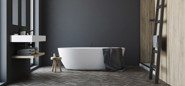 Salle de bains avec revêtement mural noir et baignoire hors sol