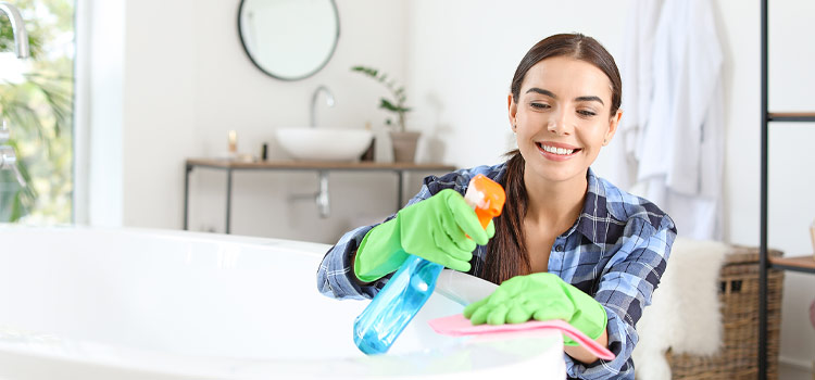 jeune femme qui nettoie une baignoire