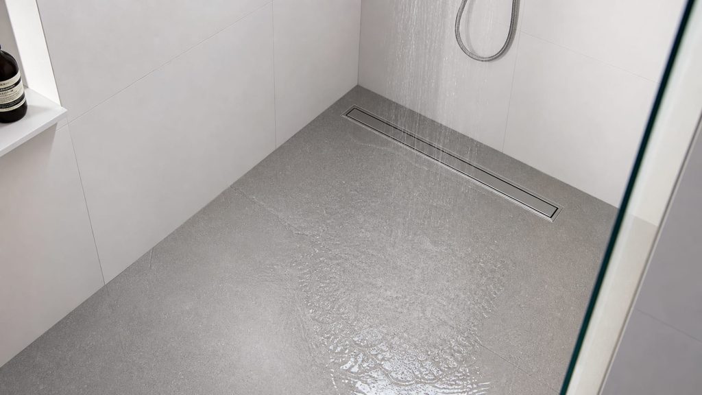 douche italienne avec l'eau qui coule et le carrelage gris
